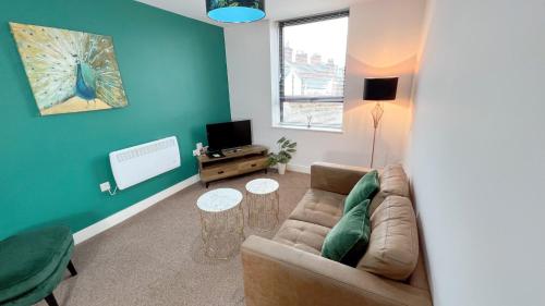a living room with a couch and a tv at Friars House, Stafford by BELL Apartments in Stafford
