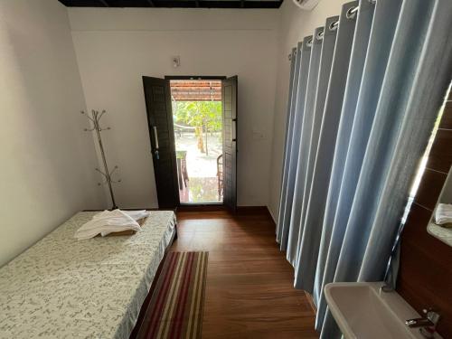 a room with a bed and a bathroom with a door at SALT LIFE MARARI BEACH VILLA in Mararikulam