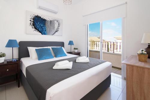 a bedroom with a large bed and a balcony at Villa Alyson in Paralimni