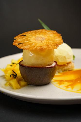 une assiette de nourriture avec un fruit sur elle dans l'établissement Logis Le Grand Hotel, à Château-du-Loir