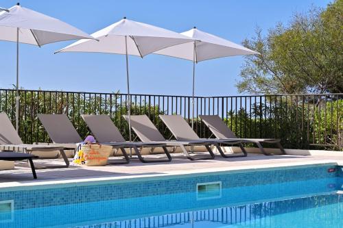 a group of chairs and umbrellas next to a pool at Résidence Les Calanques in Ajaccio