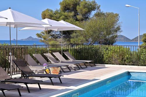 a row of chairs and umbrellas next to a swimming pool at Résidence Les Calanques in Ajaccio