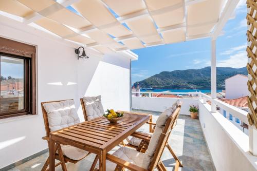 a table and chairs on a balcony with a view of the ocean at Cath's Loft in Skopelos Town