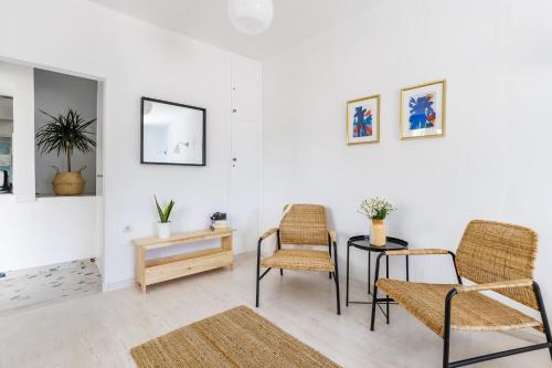 a living room with chairs and a table and a mirror at Cath's Loft in Skopelos Town