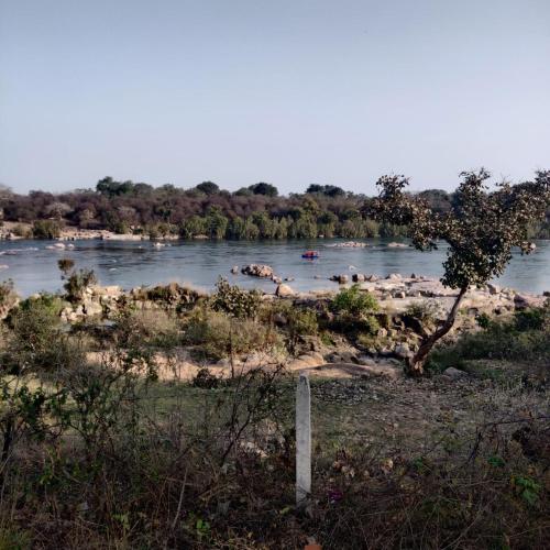 a view of a river with boats in the water at Chandera Kothi in Orchha