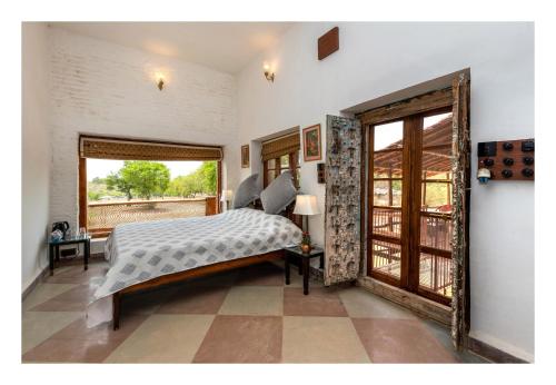 a bedroom with a bed and a large window at Chandera Kothi in Orchha