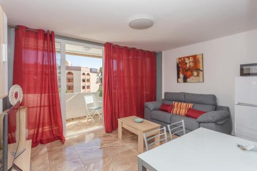 a living room with a couch and a red curtain at Lightbooking Teror Playa del Ingles in San Bartolomé