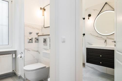 a bathroom with a toilet and a sink and a mirror at Neues Design-Apartment in Friedrichshain in Berlin