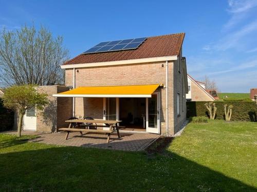 a house with a picnic table and a solar roof at Kustverhuur, Park Scheldeveste, Schelde 076 in Breskens