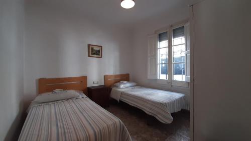 2 camas en una habitación con ventana en 1Aur04, en Calella de Palafrugell