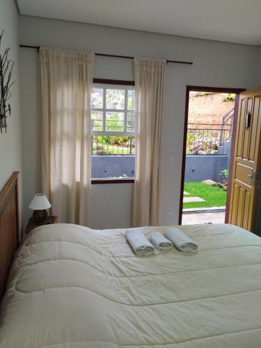a bedroom with a large bed with two towels on it at Pouso Casa da Vovó in Tiradentes