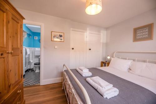 a bedroom with a bed with two towels on it at 8 The Craighurst in Southwold