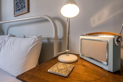a table with a television and a lamp on a bed at 8 The Craighurst, Southwold in Southwold