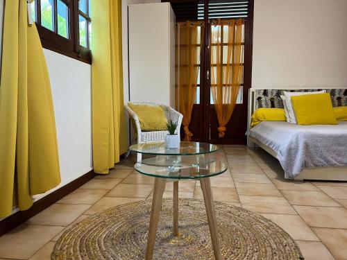 a living room with a table and a bed at Le Domaine de Jade in Saint-François