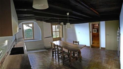 uma cozinha com uma mesa de madeira e cadeiras em Etxetxobarri, caserío independiente con vistas a la crestería de Anboto 