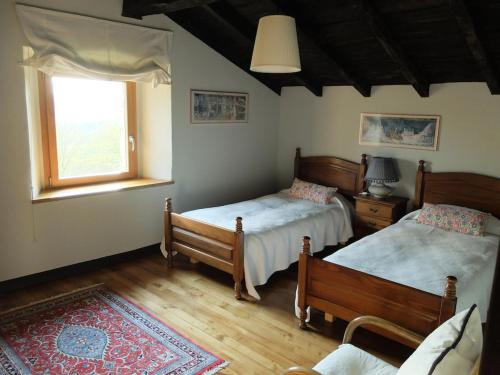 1 dormitorio con 2 camas y ventana en Etxetxobarri, caserío independiente con vistas a la crestería de Anboto, 