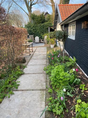 a garden path leading to a house with flowers at De Schuilhoek Private Guesthouse in Blaricum
