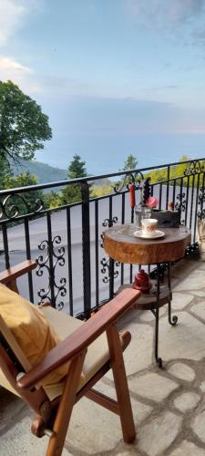 a table and a chair on a balcony at Golden Mountain in Anilio Pelion