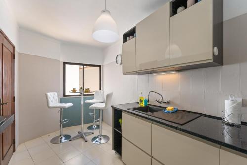 - une cuisine avec un évier et 2 chaises dans l'établissement Apartment Feliz, à Carvoeiro