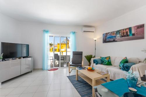 a living room with a couch and a tv at Apartment Feliz in Carvoeiro