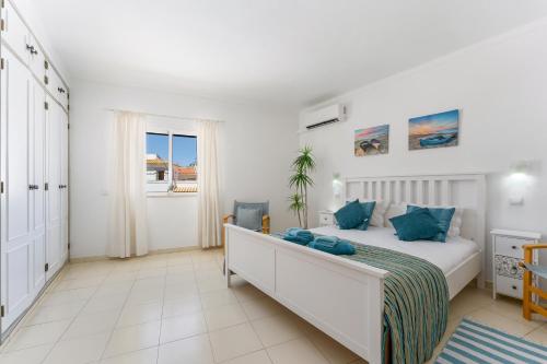 - une chambre blanche avec un lit et une fenêtre dans l'établissement Apartment Feliz, à Carvoeiro