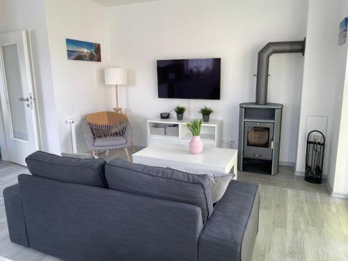 a living room with a couch and a fireplace at Strandläufer in Butjadingen OT Tossens