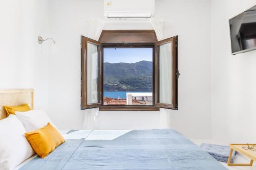 a bedroom with a window with a view of the ocean at Cath's Loft in Skopelos Town