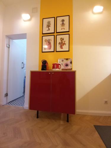 a cabinet in a room with three pictures on the wall at Art & Design Studios in Budapest