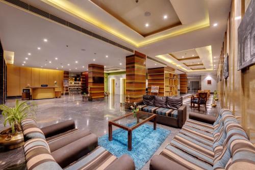 una gran sala de estar con sofás y una mesa. en Amarpreet, Chhatrapati Sambhajinagar - AM Hotel Kollection, en Aurangabad