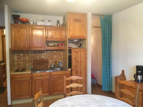 - une cuisine avec des placards en bois et une table dans une pièce dans l'établissement T1 Proche Grand Bornand Et Lac, à Les Villards-sur-Thônes