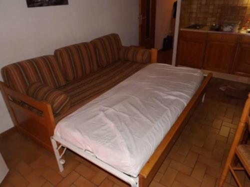 un lit avec un canapé et une chaise dans une pièce dans l'établissement T1 Proche Grand Bornand Et Lac, à Les Villards-sur-Thônes