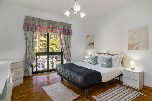 a bedroom with a bed and a window at WHome Perfect Family Hideout Residence w/AC & 4BR + 5BA in Cascais