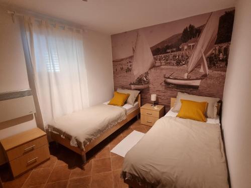 Pokój z dwoma łóżkami i obrazem na ścianie w obiekcie Holiday house Marea with jacuzzi w Crikvenicy