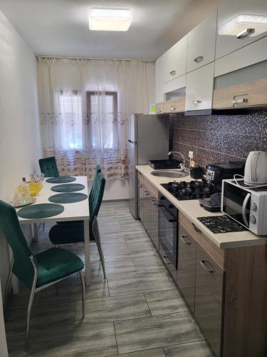 a kitchen with a table and a stove top oven at Apartament NECTARIA in Băile Herculane