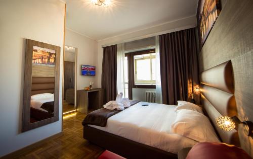 Habitación de hotel con cama y espejo en Love of Rome, en Roma