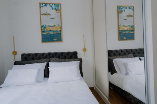 two beds with white pillows in a bedroom at Terra Apartments in Vrnjačka Banja