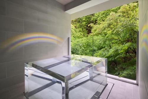 a glass table in a room with a window at Ryokan Sumiya Kihoan in Kameoka