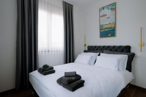 um quarto com uma cama branca e toalhas em Terra Apartments em Vrnjačka Banja