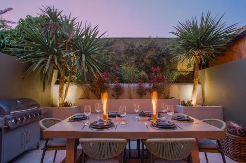 a table with candles on a patio with palm trees at The Luxury Fulham Townhouse in London
