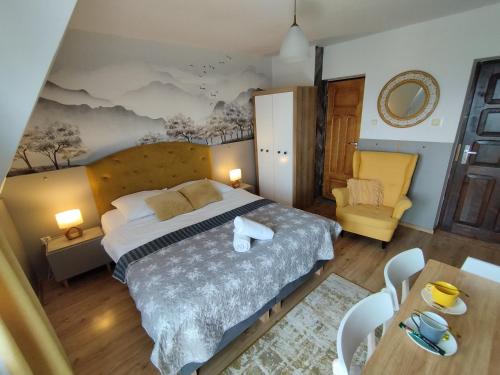 グリツァルフにあるTatrzańska Panoramaのベッドルーム(大型ベッド1台、黄色い椅子付)
