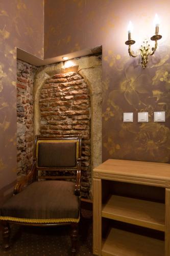 a room with a chair and a brick wall at Hotel Am Ring in Sibiu