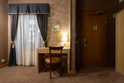 a room with a desk and a chair next to a door at Hotel Am Ring in Sibiu