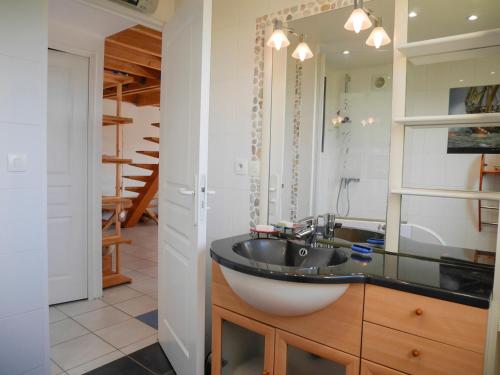 une salle de bain avec un lavabo et un miroir dans l'établissement Maison spacieuse au calme, proche plage et commerces, avec jardin et terrasse au Palais. - FR-1-418-202, au Palais
