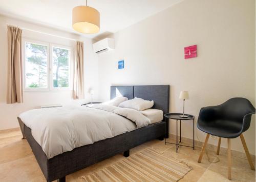 - une chambre avec un lit et une chaise noire dans l'établissement Maison Esterel in Saint-Raphael, à Saint-Raphaël