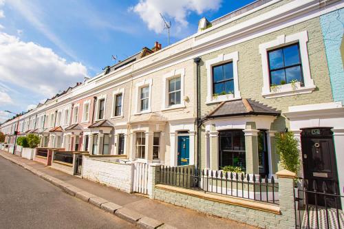 uma fila de casas brancas numa rua em The Luxury Fulham Townhouse em Londres