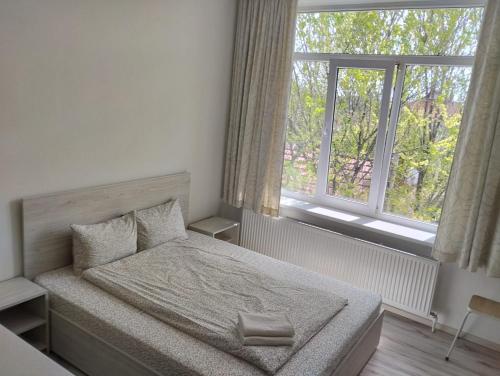 a small bedroom with a bed and two windows at PARK-hotel in Cahul