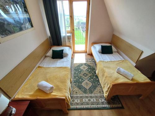 two beds in a small room with a window at Tatrzańska Panorama in Gliczarów