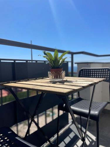 a wooden table with a potted plant on a balcony at Bellevue Herculaneum B&B in Ercolano