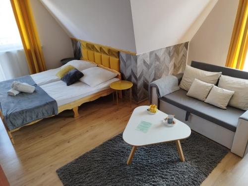 グリツァルフにあるTatrzańska Panoramaのベッド1台とソファが備わる小さな客室です。