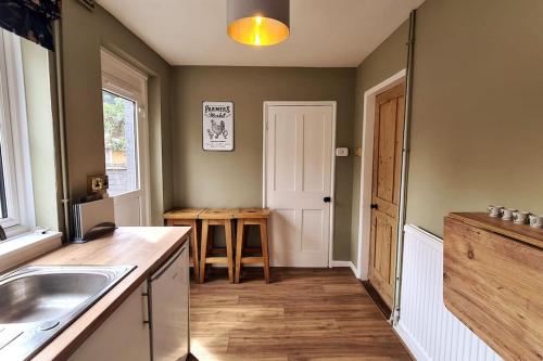 a kitchen with a sink and a wooden floor at Gorgeous Two Bedroom House in Ely in Ely